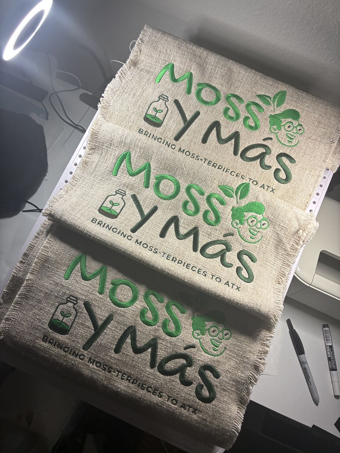 Moss Y Mas business logo embroidered on fringed linen panels